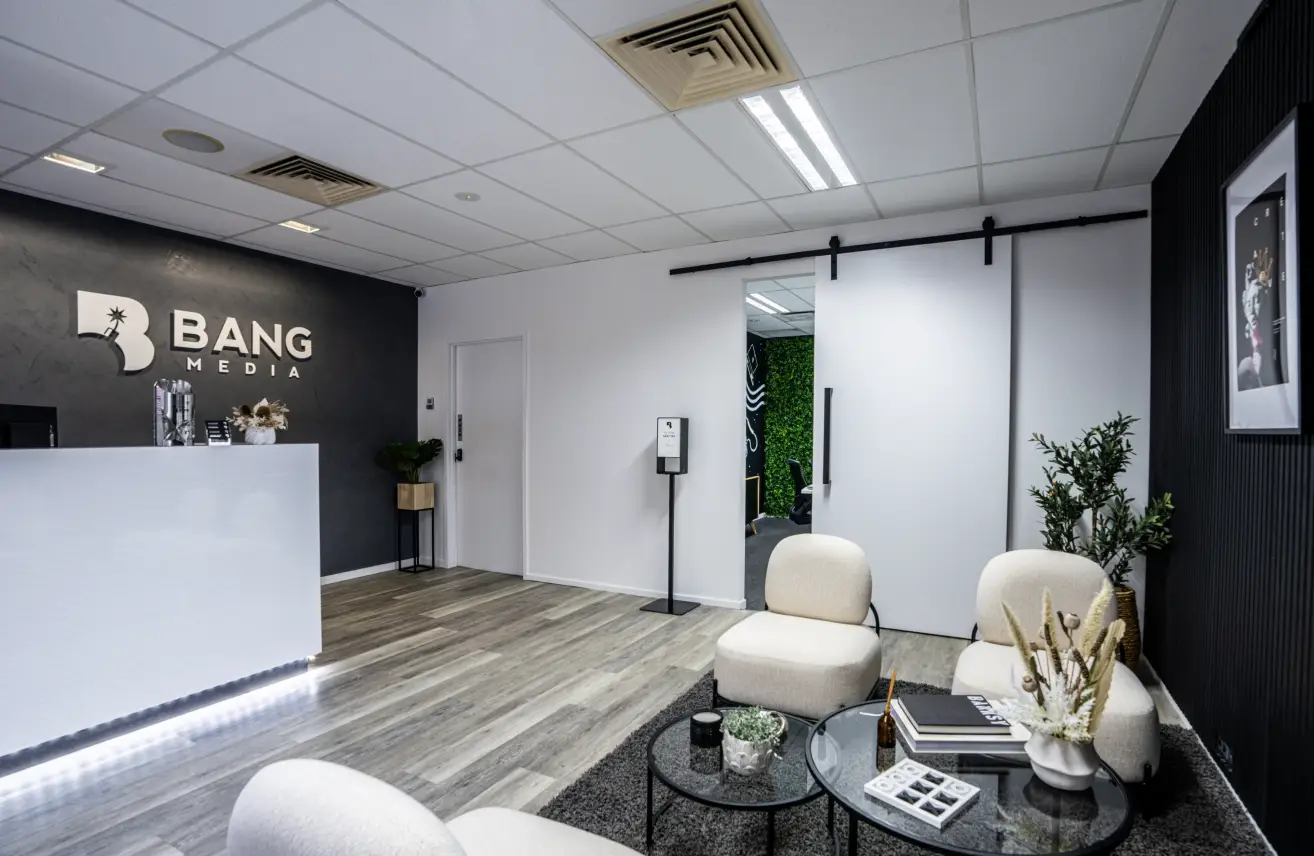 A reception area with white chairs and a black table