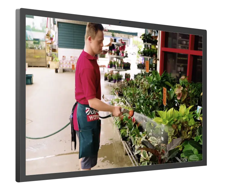 A man is watering plants in a greenhouse