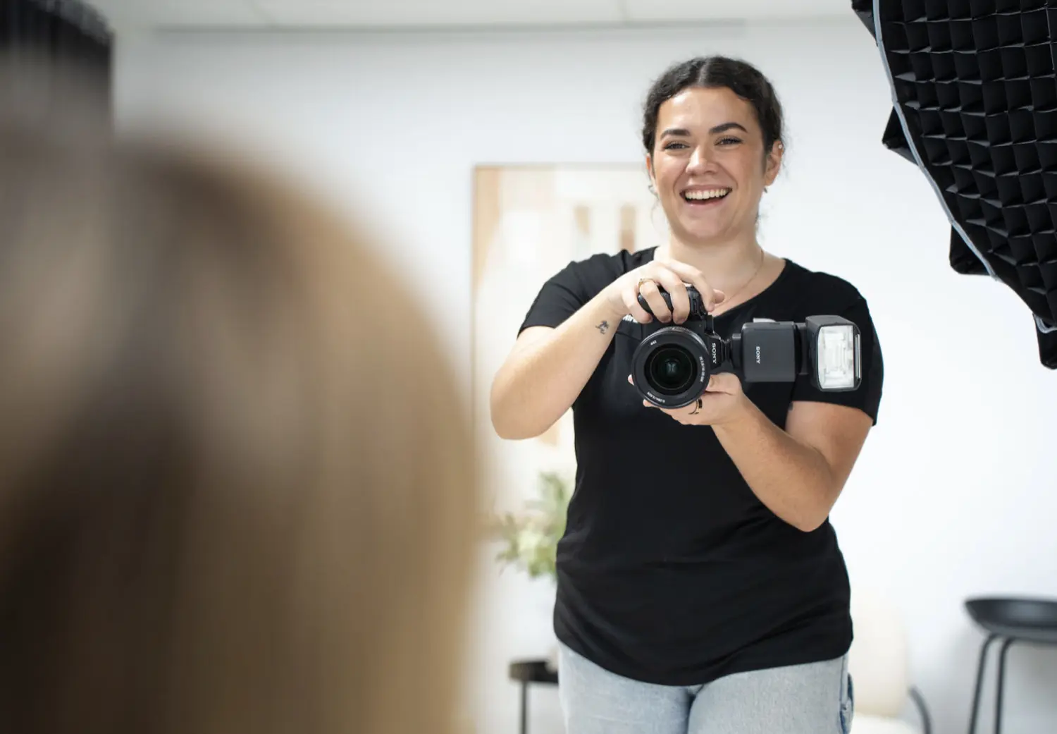 A woman holding a camera in front of a mirror