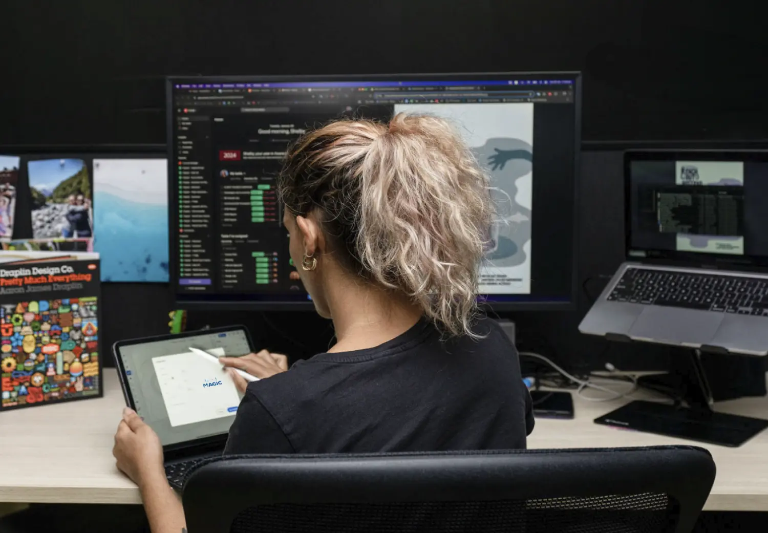 A woman sitting at a desk with a tablet in front of her