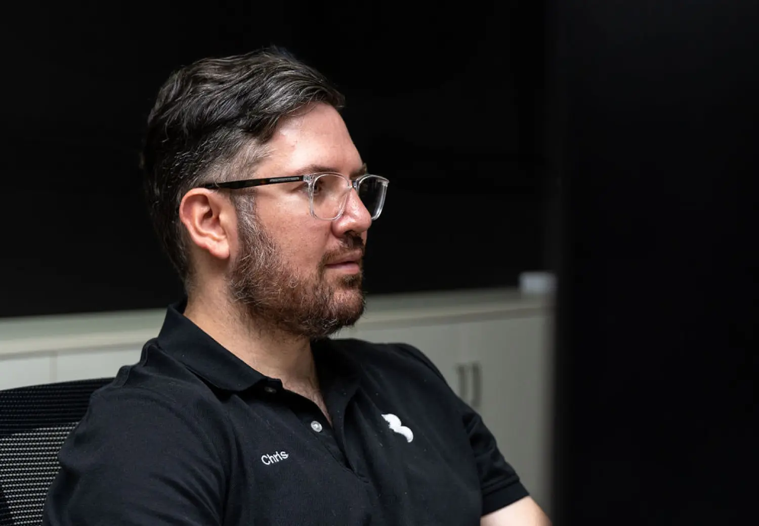 A man with glasses sitting in a chair