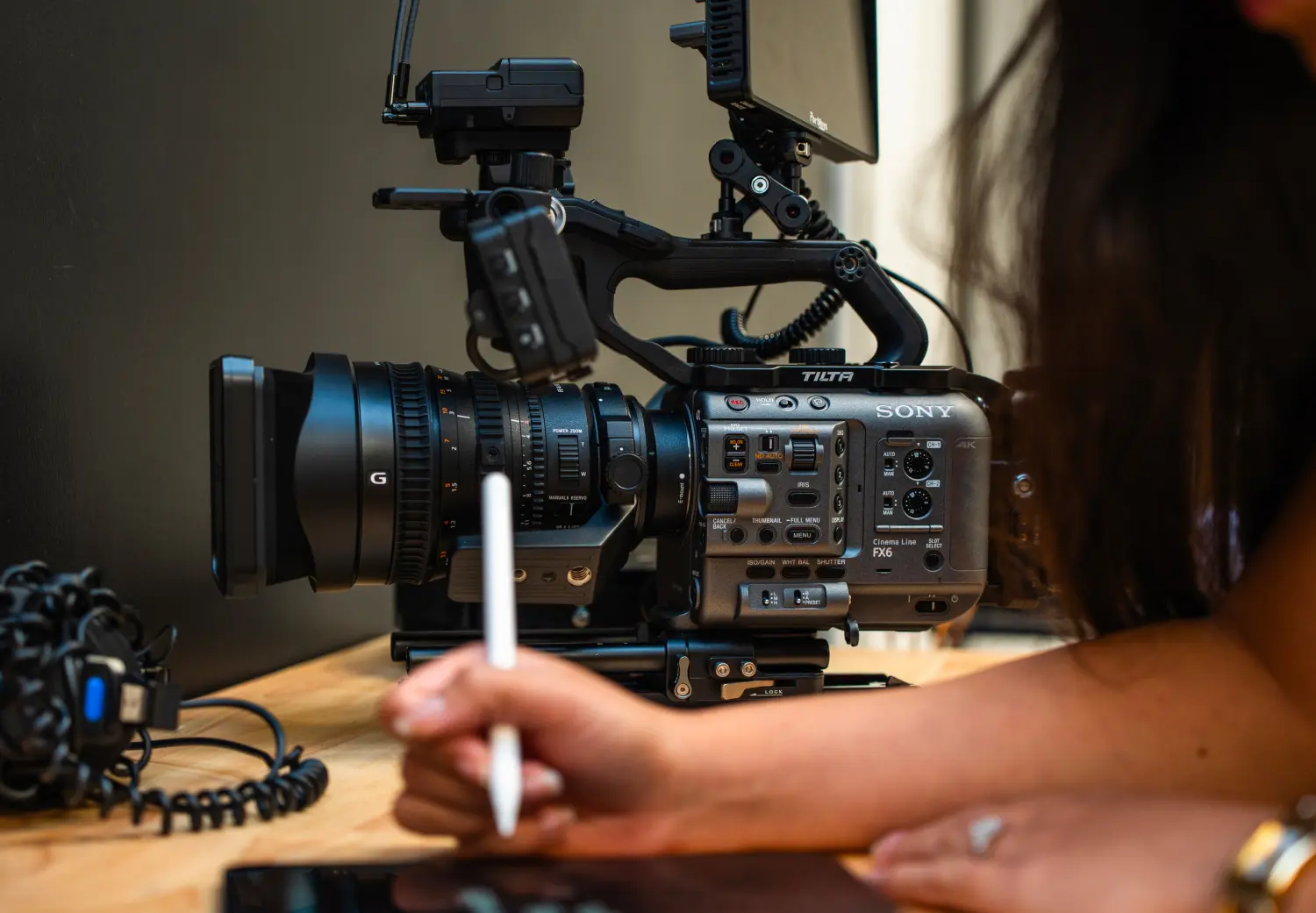 A woman is holding a camera and writing on a piece of paper