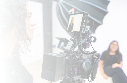 A woman sitting in front of a camera with headphones on