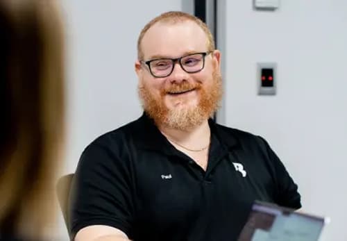 A man with a beard sitting at a table