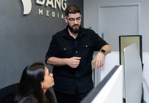 A man standing next to a woman in an office